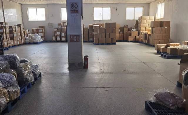 荣岛检品车间二组,检品员整理并检查叠装服装